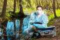 biologist takes water from a forest river to study the composition