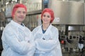 Biologist team talking and wearing hairnet in factory Royalty Free Stock Photo
