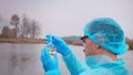 Biologist Water Analyzer Examines Liquid In Flask For Visible Contaminants, Ecological Water Sampling Determine Level Of