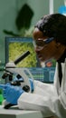 Biologist woman looking at test sample under microscope