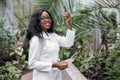 Biotechnology, agronomy, science and engineering concept. Young black female scientist holding test tube with sample and