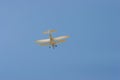 Biplane flying in the blue sky Royalty Free Stock Photo