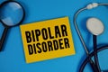 Bipolar Disorder text with Stethoscope and magnifying glass on blue background Royalty Free Stock Photo