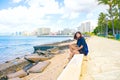 Biracial Asian teen girl sittig along empty Waikiki Beach Royalty Free Stock Photo