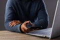 Biracial businessman using smartphone and laptop on grey background Royalty Free Stock Photo