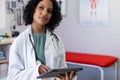 Biracial female doctor wearing sthethoscope, using tablet at doctor's office Royalty Free Stock Photo