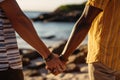 Biracial gay couples hands embrace on a sunlit beach together