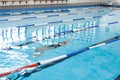 Biracial girl in swimsuit and cap trains in indoor pool, copy space