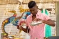 Biracial male bartender pouring cocktail from shaker at beach bar, unaltered Royalty Free Stock Photo