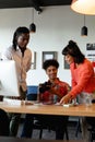 Biracial photographer discussing with multiracial colleagues in meeting at creative office Royalty Free Stock Photo