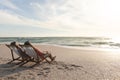 Biracial senior man and woman relaxing while sitting on folding chairs at beach Royalty Free Stock Photo