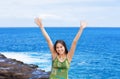 Biracial teen girl arms raised by ocean water in praise