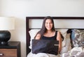 Biracial teen girl sitting in bed studying on laptop computer Royalty Free Stock Photo