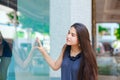 Biracial teen girl window shopping in urban setting downtown