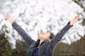 Teen girl outdoors arms outstretched enjoying snowfall in winter Royalty Free Stock Photo