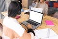 Biracial teenage girl studying online over laptop while mother talking over smartphone at home Royalty Free Stock Photo