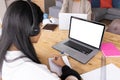 Biracial teenage girl writing while studying online and mother working over laptop at home Royalty Free Stock Photo