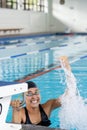 Biracial young female swimmer wearing goggles celebrating indoors in pool, copy space Royalty Free Stock Photo