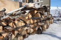 Birch wood logs piled in a pile in the snow prepared for kindling for the winter in a stack