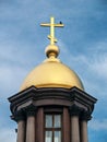 Golden dome of the chapel with a bird at the top of the cross