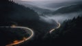 A bird eye scenery view of a winding road cutting turns through clouds of serpentine a dense forest , mountain landscape.Top Down Royalty Free Stock Photo