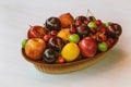 Bird eye view of a bowl of colorful mixed fruit, apples, peaches, green and red plums, cherries and lemon.