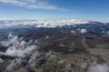 Bird eye view of clouds that are running over a mountainous green landscape Royalty Free Stock Photo