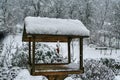 Bird feeder with hanged bacon rind covered with snow