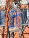 A bird feeder made from a large plastic bottle