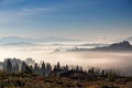 Bird flying over hills and village. Foggy morning in mountains Royalty Free Stock Photo