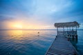 Dock with a palapa roof during sunset and calm blue water Royalty Free Stock Photo