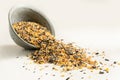 Bird food from mixed seeds like sunflower, corn, millet and more, are falling out of a bowl on a light background, copy space Royalty Free Stock Photo