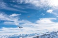 A bird in the foreground and a paraglider flying over the snowy mountains in the Swiss Alps on a sunny day Royalty Free Stock Photo