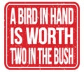 A BIRD IN HAND IS WORTH TWO IN THE BUSH, words on red stamp sign Royalty Free Stock Photo