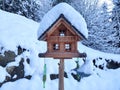 Bird house artfully designed covered with snow in snowy winter scenery Royalty Free Stock Photo