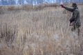 The bird hunter walks across the field with his dog on a partridge hunt and shows her where to go