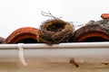 Bird nest empty on roof white house facade Royalty Free Stock Photo