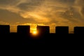 Bird perched atop a castle merlon at sunset Royalty Free Stock Photo