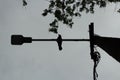 Bird on pole. Silhouette of bird sitting on crossbar. Raven lurked