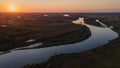 Bird`s eye landscape drone shot of curved river and lakes and forest during sunrise