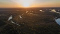 Bird`s eye landscape view with curved river and lakes and forest during sunrise