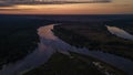 Bird`s eye landscape view of the sunrise above forest and river curves Royalty Free Stock Photo