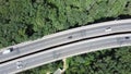 Aerial view of cars are moving through the forest on the road in the summer. Royalty Free Stock Photo