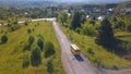 Bird& x27;s-eye view. Clip. A long road on which a yellow bus rides against a background of green trees and grass Royalty Free Stock Photo