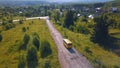 Bird's-eye view. Clip. A long road on which a yellow bus rides against a background of green trees and grass Royalty Free Stock Photo