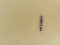 Bird\'s eye view of a narrow wooden boat full of people sailing in a dirty river Royalty Free Stock Photo