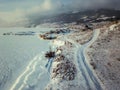 A bird\'s eye view of a ridgeline half-covered with snow in a forest with a sunburst in the upper left corner of the frame. Royalty Free Stock Photo