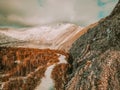 A bird\'s eye view of a ridgeline half-covered with snow in a forest with a sunburst in the upper left corner of the frame. Royalty Free Stock Photo