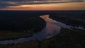 Bird`s eye view of the sunrise above forest and river curves Royalty Free Stock Photo