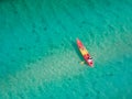 A bird`s-eye view of a woman kayaking in the middle of the sea